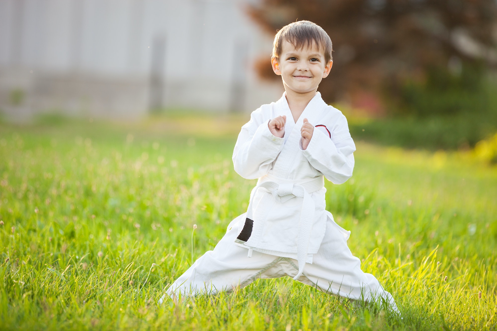 Preschool boy practicing karate outdoors